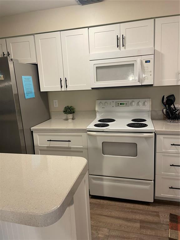 14531 Walsingham Road, Unit 203 Largo, FL 33774 - Photo 9 of 24 a kitchen with white cabinets and white appliances