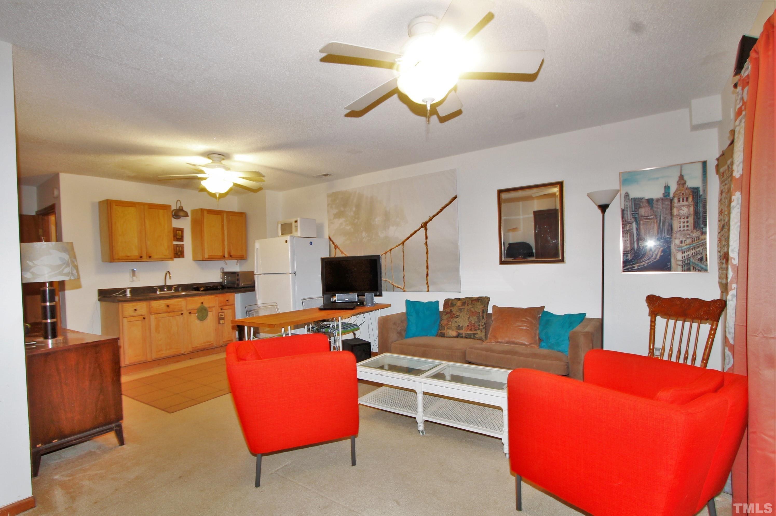 17 Prestwick Place, Unit 17 Durham, NC 27705 - Photo 21 of 27 a living room with furniture kitchen view and a chandelier