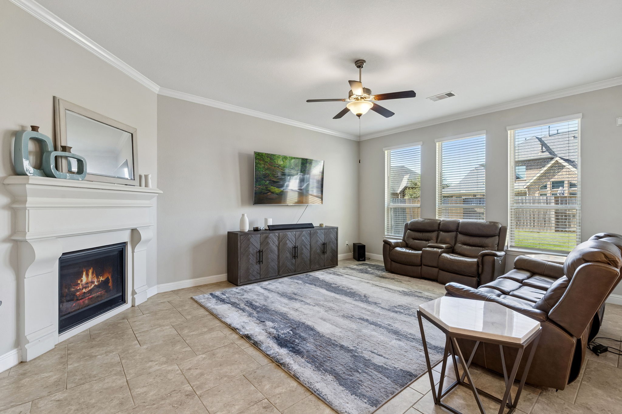 1619 Dove Ridge Drive Katy, TX 77493 - Photo 4 of 28 The spacious living area serves as a central hub, highlighted by a classic fireplace and tile flooring. Large windows fill the room with an airy atmosphere, offering views of the expansive backyard.