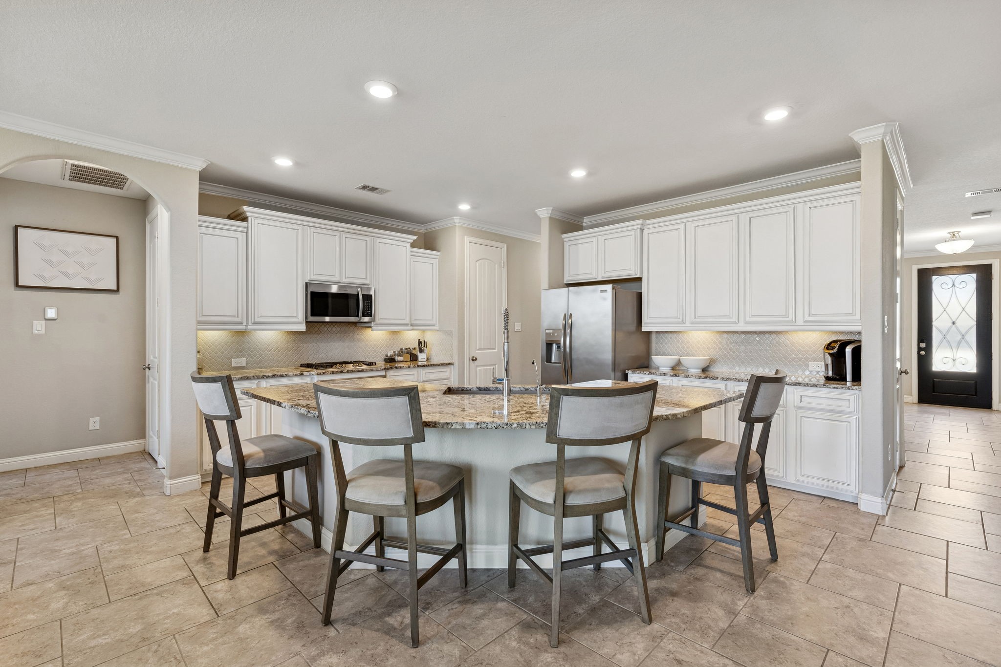 1619 Dove Ridge Drive Katy, TX 77493 - Photo 5 of 28 The chef’s kitchen is open to the family room and features premium granite countertops and an expansive breakfast bar. Bright cabinetry is accented by coordinating backsplash and under-cabinet lighting.