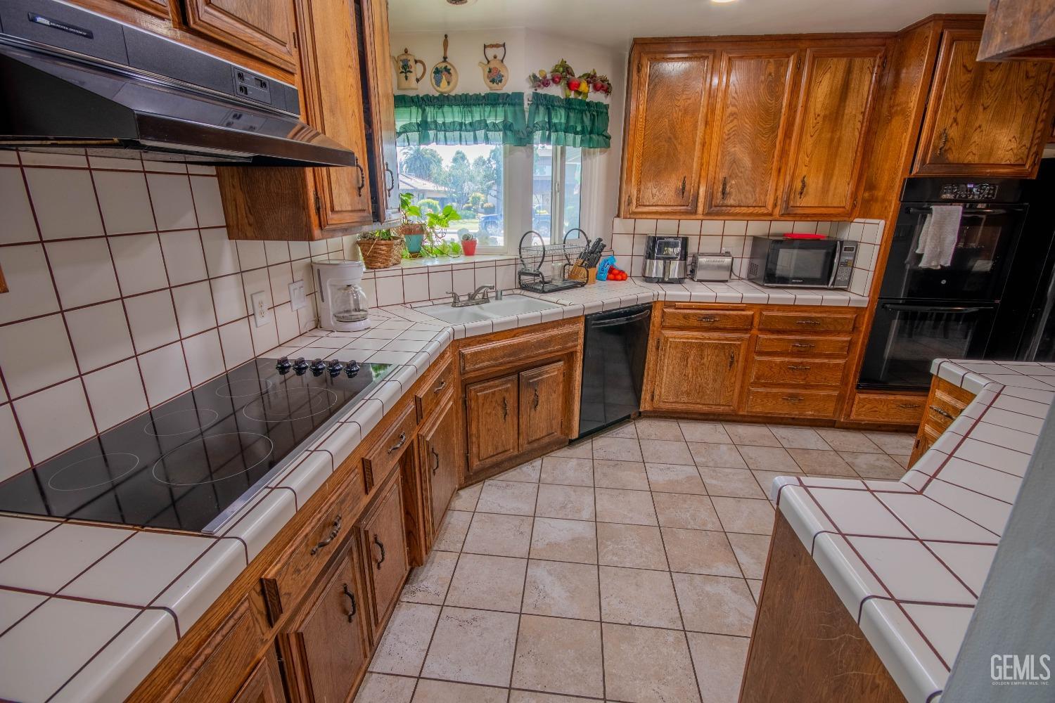 Undisclosed Address Bakersfield, CA 93309 - Photo 14 of 46 a kitchen with stainless steel appliances a sink window and cabinets