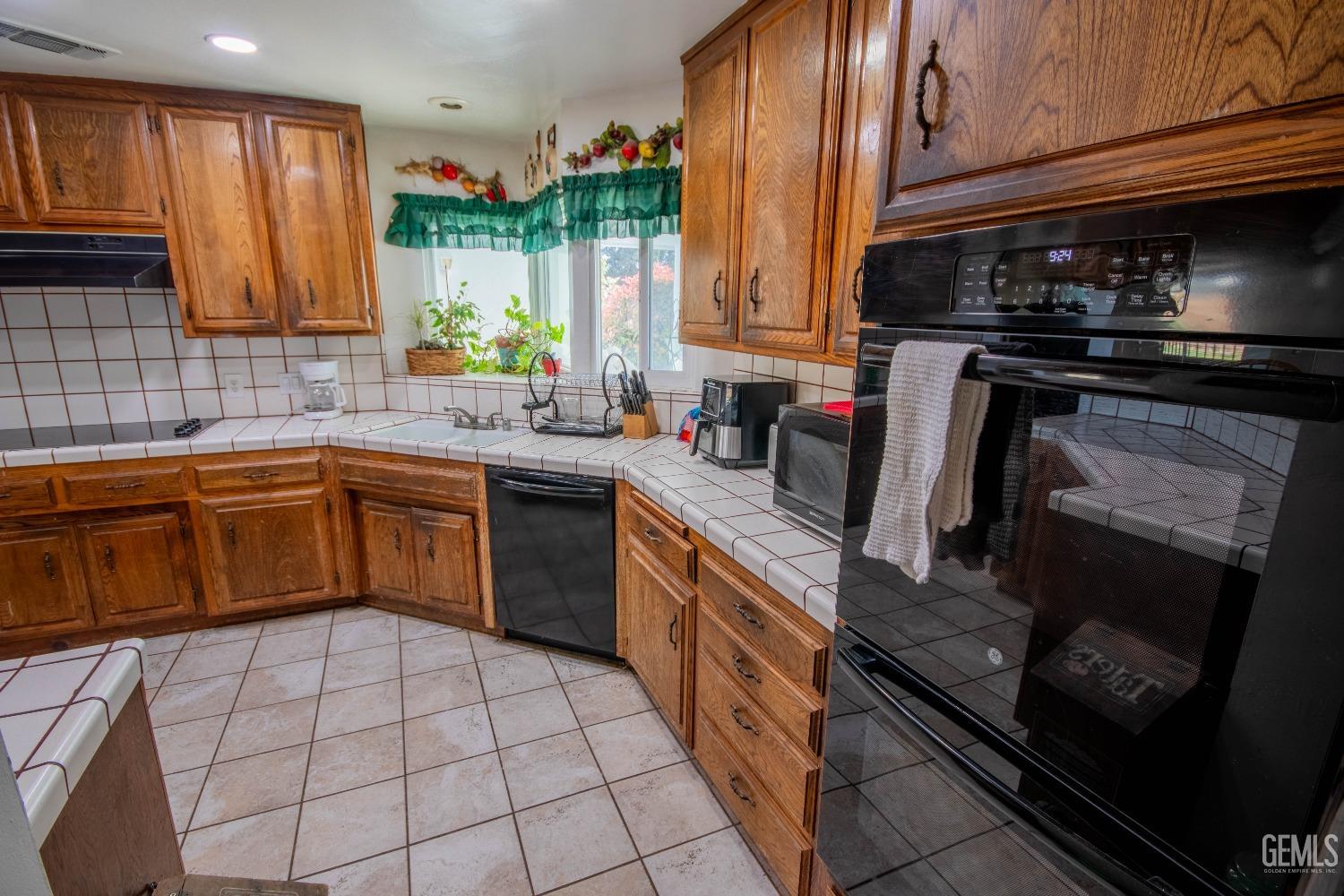 Undisclosed Address Bakersfield, CA 93309 - Photo 16 of 46 a kitchen with a sink stove and cabinets