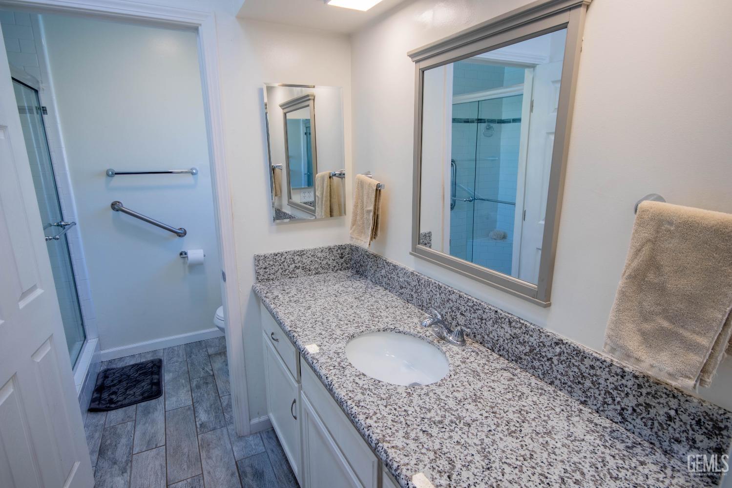 Undisclosed Address Bakersfield, CA 93309 - Photo 22 of 46 a bathroom with a granite countertop sink and a mirror