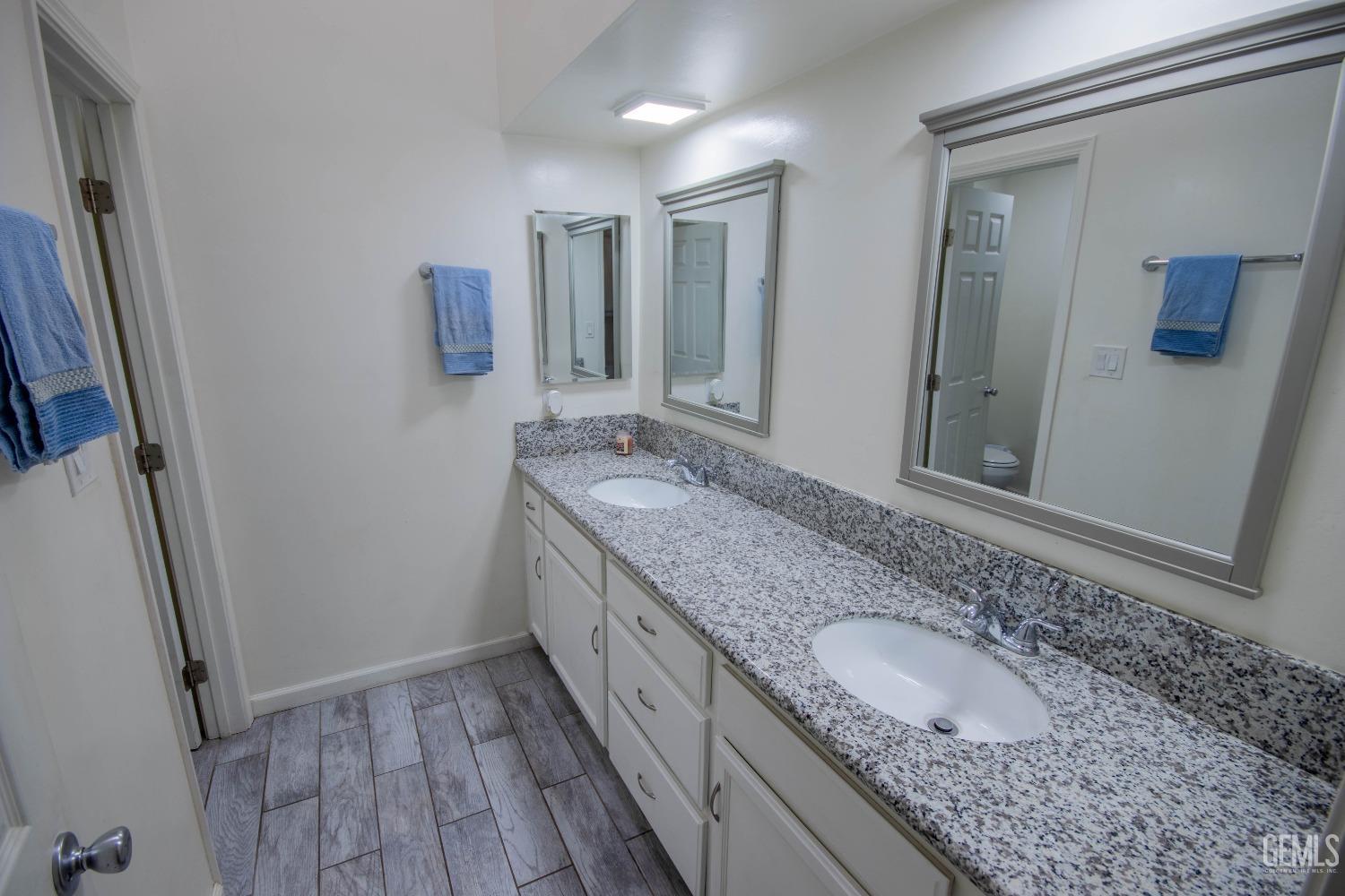 Undisclosed Address Bakersfield, CA 93309 - Photo 30 of 46 a bathroom with a granite countertop double vanity sink and mirror