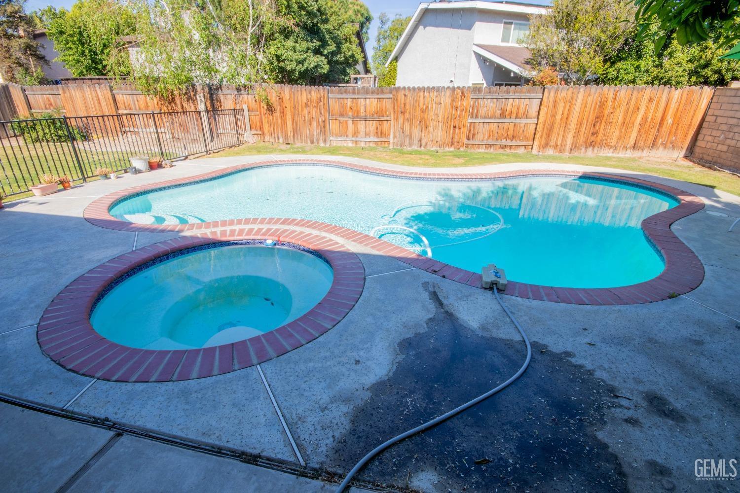 Undisclosed Address Bakersfield, CA 93309 - Photo 35 of 46 a view of a swimming pool with a yard and wooden fence