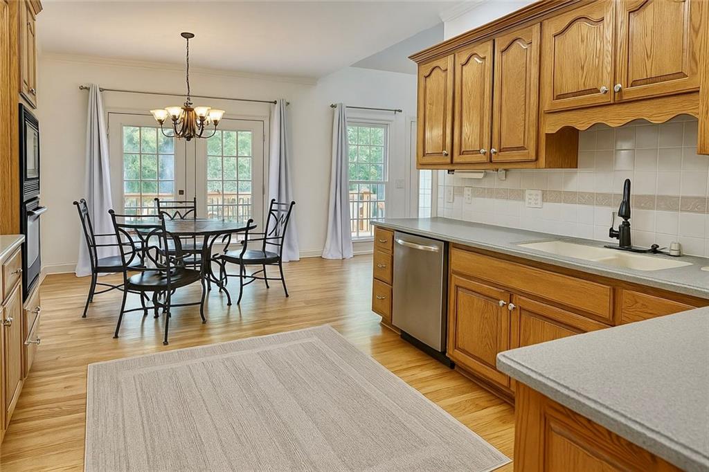 2014 Hubbard Court Villa Rica, GA 30180 - Photo 17 of 41 a kitchen with stainless steel appliances granite countertop wooden floor a dining table and chairs