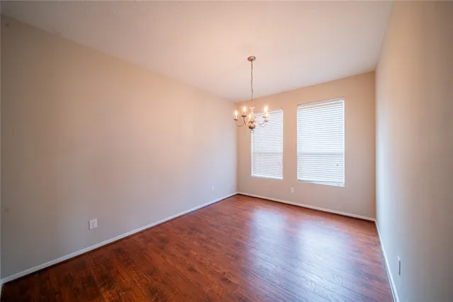 a view of a room with wooden floor chandelier and a window