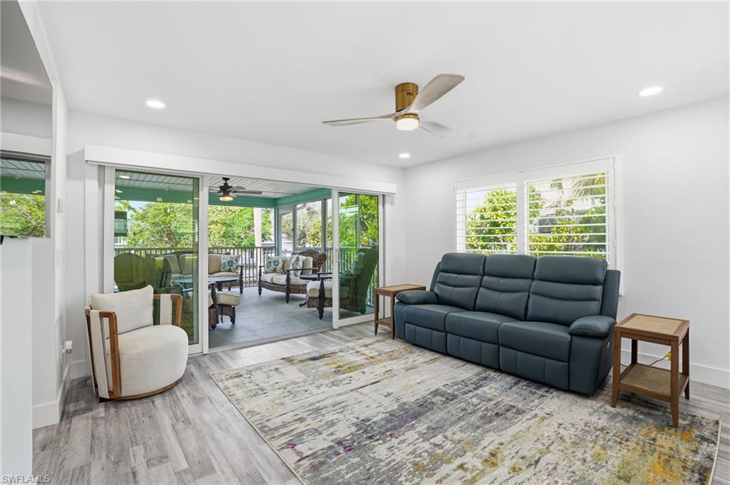 270 Dundee Road Fort Myers Beach, FL 33931 - Photo 8 of 48 Living area featuring a ceiling fan, wood finished floors, a sunroom, and recessed lighting - Virtually Edited Image