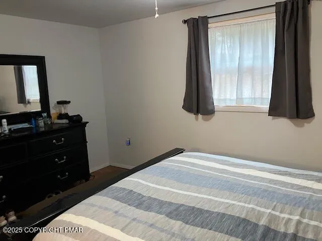 a bedroom with a bed and a flat tv screen next to a window