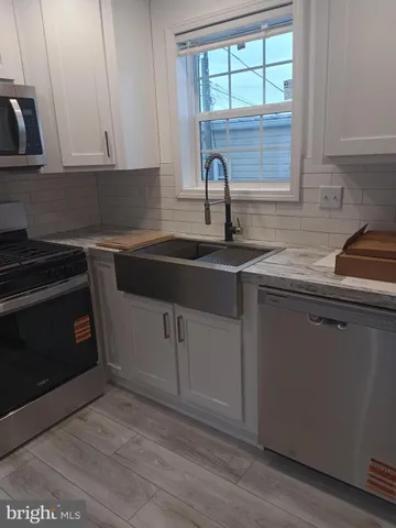 a kitchen with cabinets appliances a sink and a window