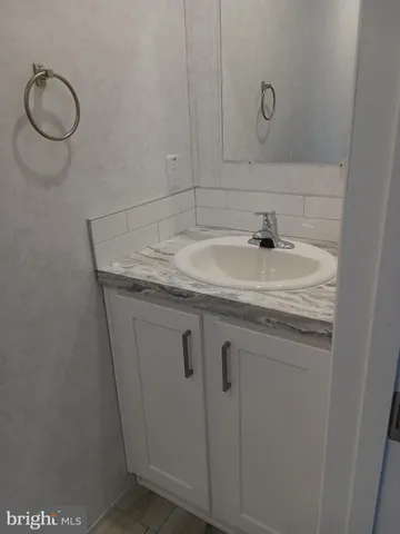 a bathroom with a granite countertop sink and a mirror