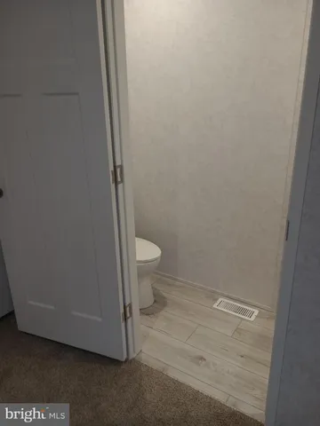 a bathroom with a granite countertop toilet and a sink