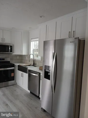 a kitchen with stainless steel appliances and refrigerator