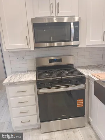 a stove top oven sitting inside of a kitchen