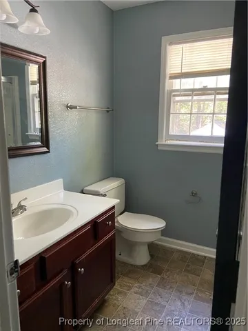 a bathroom with a sink toilet and window
