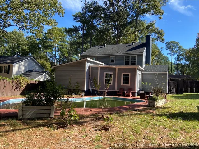 a front view of a house with swimming pool and a yard