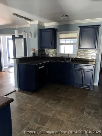 a kitchen with granite countertop a stove a sink and a refrigerator