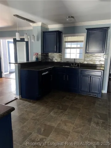 a kitchen with granite countertop a stove a sink and a refrigerator