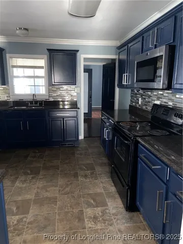 a kitchen with stainless steel appliances granite countertop a stove a sink and a microwave