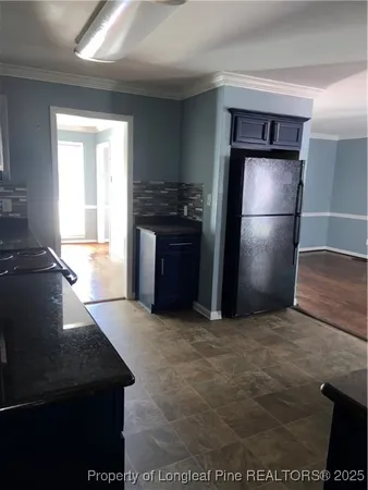 a kitchen with kitchen island a counter top space cabinets and a refrigerator