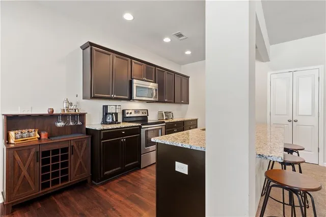 a large kitchen with stainless steel appliances granite countertop a stove a sink dishwasher and a refrigerator