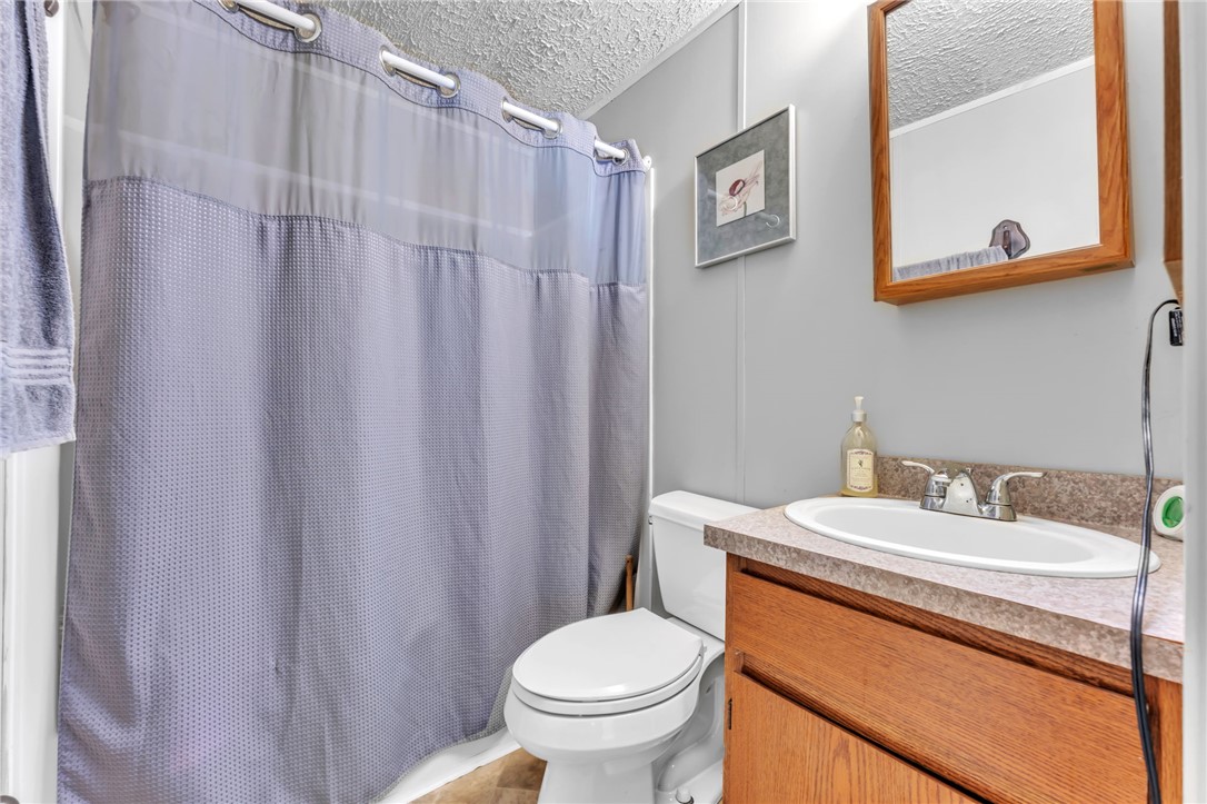137 East Reedy Fork Road Seneca, SC 29678 - Photo 18 of 28 This bathroom features a functional vanity with a sleek countertop and a clean, accessible toilet.