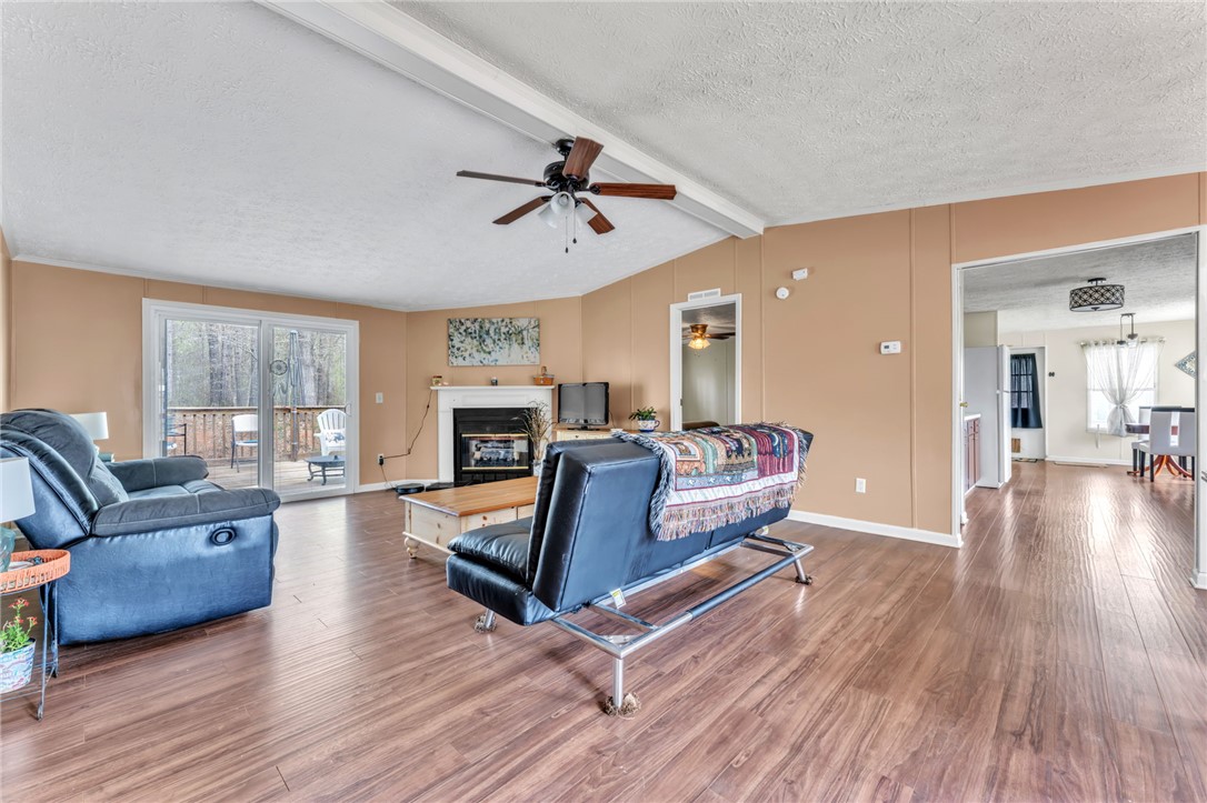 137 East Reedy Fork Road Seneca, SC 29678 - Photo 8 of 28 Warm and inviting living room featuring flooring and a cozy fireplace for relaxed gatherings.