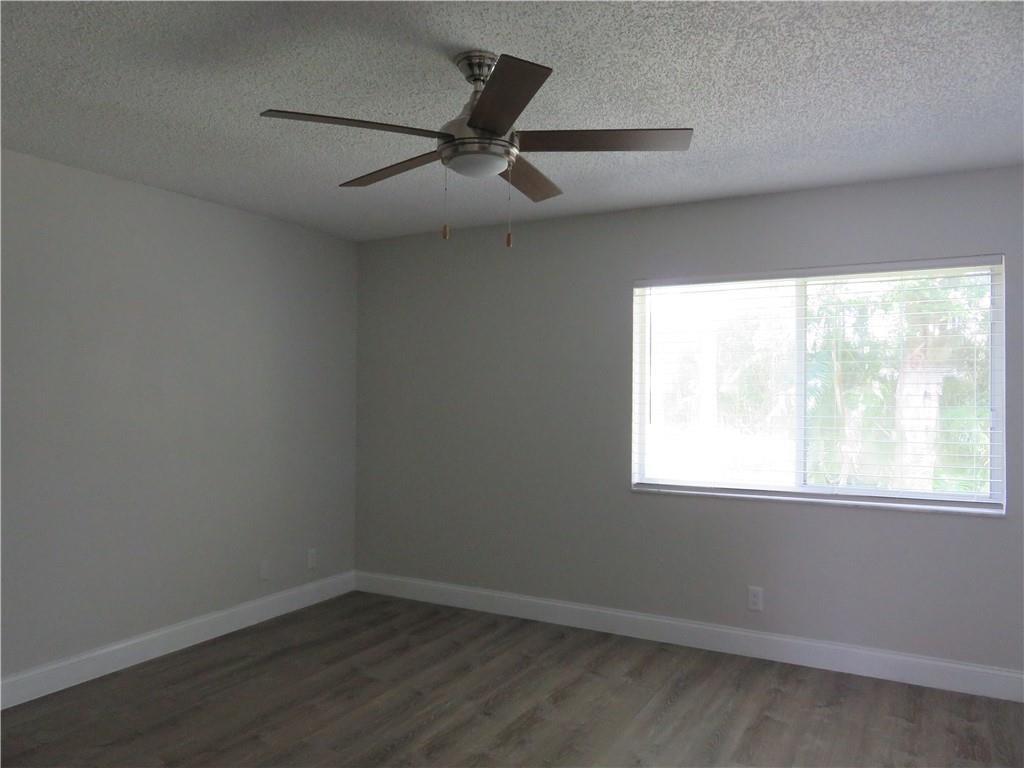9764 Kamena Circle Boynton Beach, FL 33436 - Photo 12 of 18 an empty room with wooden floor and windows