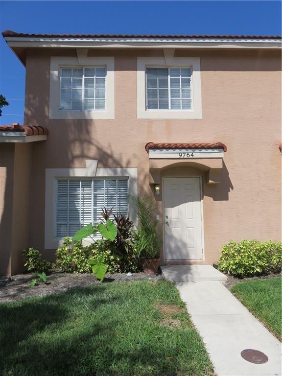 9764 Kamena Circle Boynton Beach, FL 33436 - Photo 2 of 18 a front view of a house with garden
