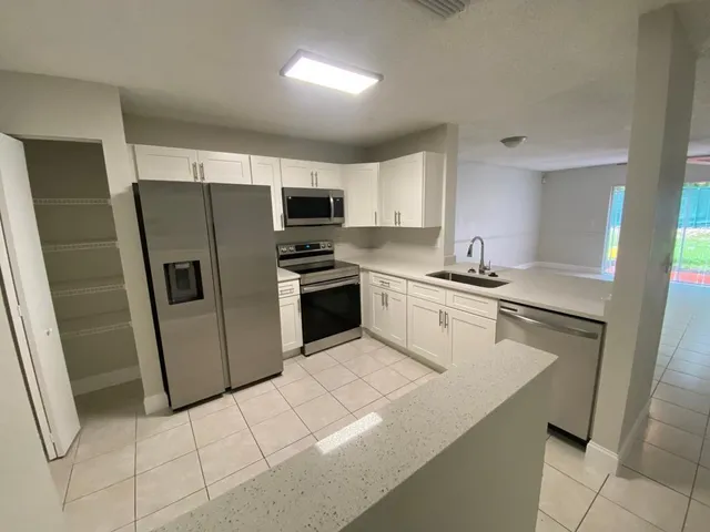 a kitchen with stainless steel appliances a refrigerator sink and microwave