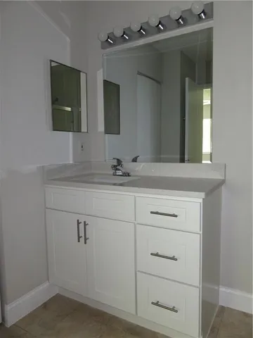 a bathroom with a sink vanity and mirror