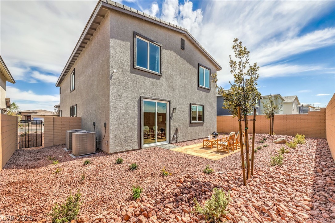 1017 Copper Robin Street Henderson, NV 89011 - Photo 39 of 43 Photo is representational only; actual home finishes may vary. Rear view of property featuring stucco siding, a fenced backyard, and cooling unit
