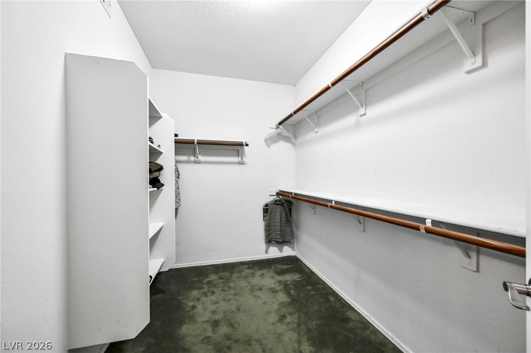 10730 Amber Ridge Drive, Unit 101 Las Vegas, NV 89144 - Photo 22 of 32 Ample storage solutions define this spacious walk-in closet, ready for personalized organization.