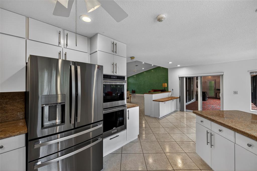 10405 Canoe Brook Circle Boca Raton, FL 33498 - Photo 24 of 56 a kitchen with stainless steel appliances a refrigerator a stove and white cabinets