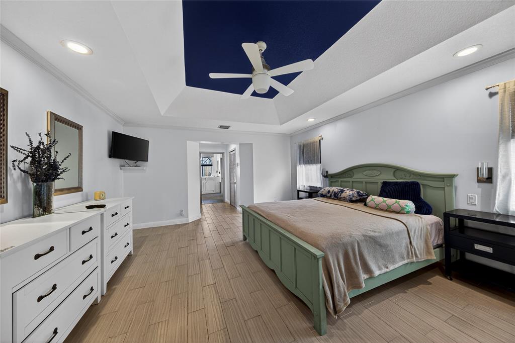 10405 Canoe Brook Circle Boca Raton, FL 33498 - Photo 26 of 56 a bedroom with a large bed and a flat tv screen on dresser