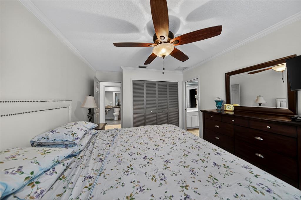 10405 Canoe Brook Circle Boca Raton, FL 33498 - Photo 30 of 56 a bedroom with a bed and a mirror on dresser