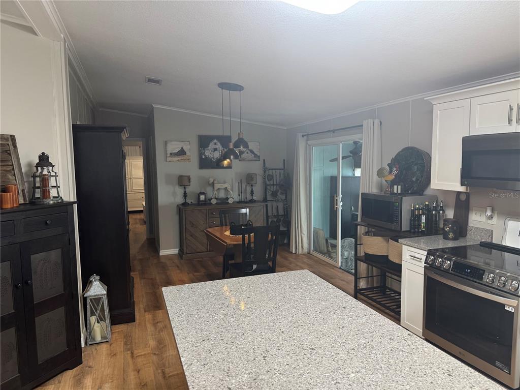 1001 Starkey Road, Unit 310 Largo, FL 33771 - Photo 7 of 25 a kitchen with stainless steel appliances kitchen island granite countertop a refrigerator stove and sink