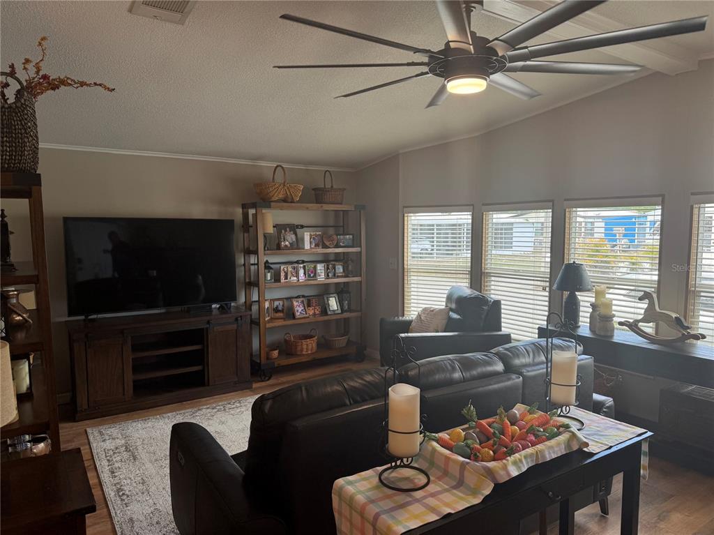1001 Starkey Road, Unit 310 Largo, FL 33771 - Photo 8 of 25 a living room with furniture a flat screen tv and floor to ceiling window