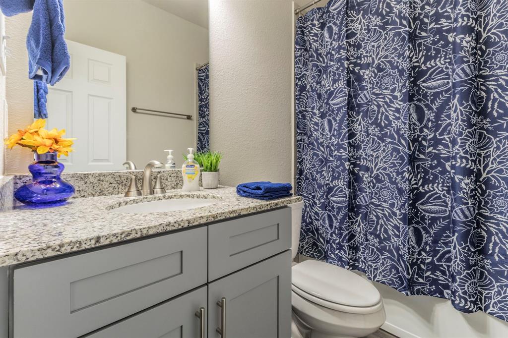 626 Ruthye Lane Pilot Point, TX 76258 - Photo 11 of 27 Bathroom with a textured wall, vanity, and curtained shower