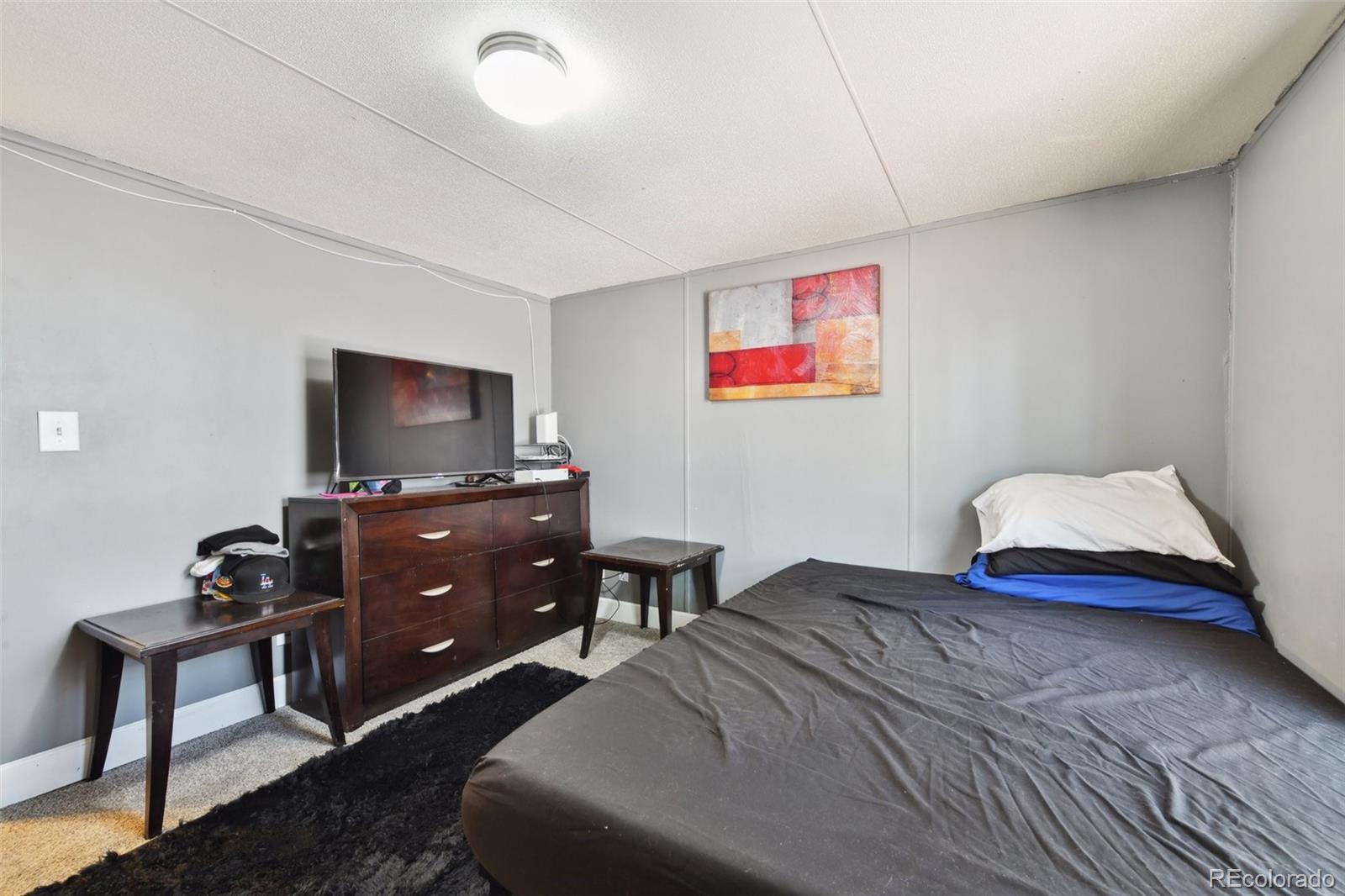 9400 North Elm Court Denver, CO 80260 - Photo 12 of 23 a bedroom with a bed and a television