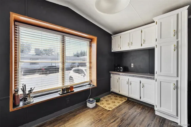 a kitchen with granite countertop white cabinets and white appliances
