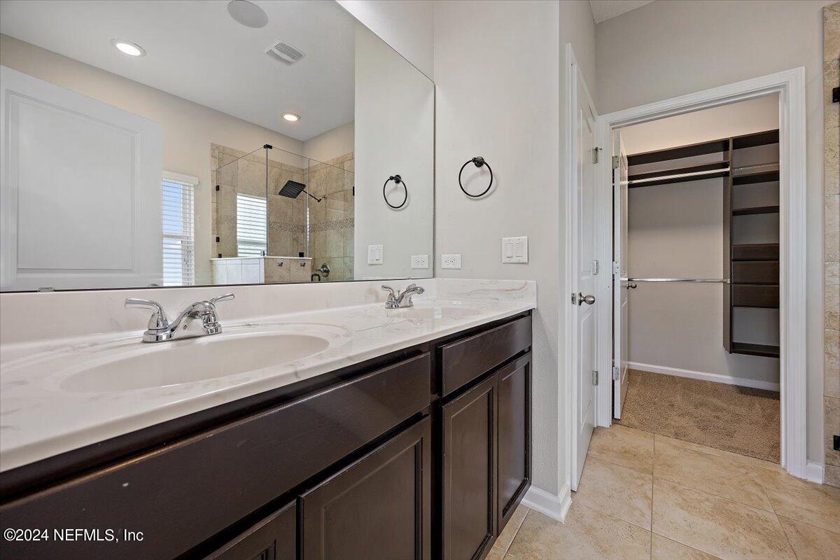 9802 Kevin Road Jacksonville, FL 32257 - Photo 15 of 23 a bathroom with a double vanity sink and a mirror