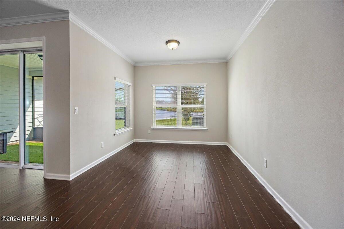 9802 Kevin Road Jacksonville, FL 32257 - Photo 9 of 23 an empty room with wooden floor and windows