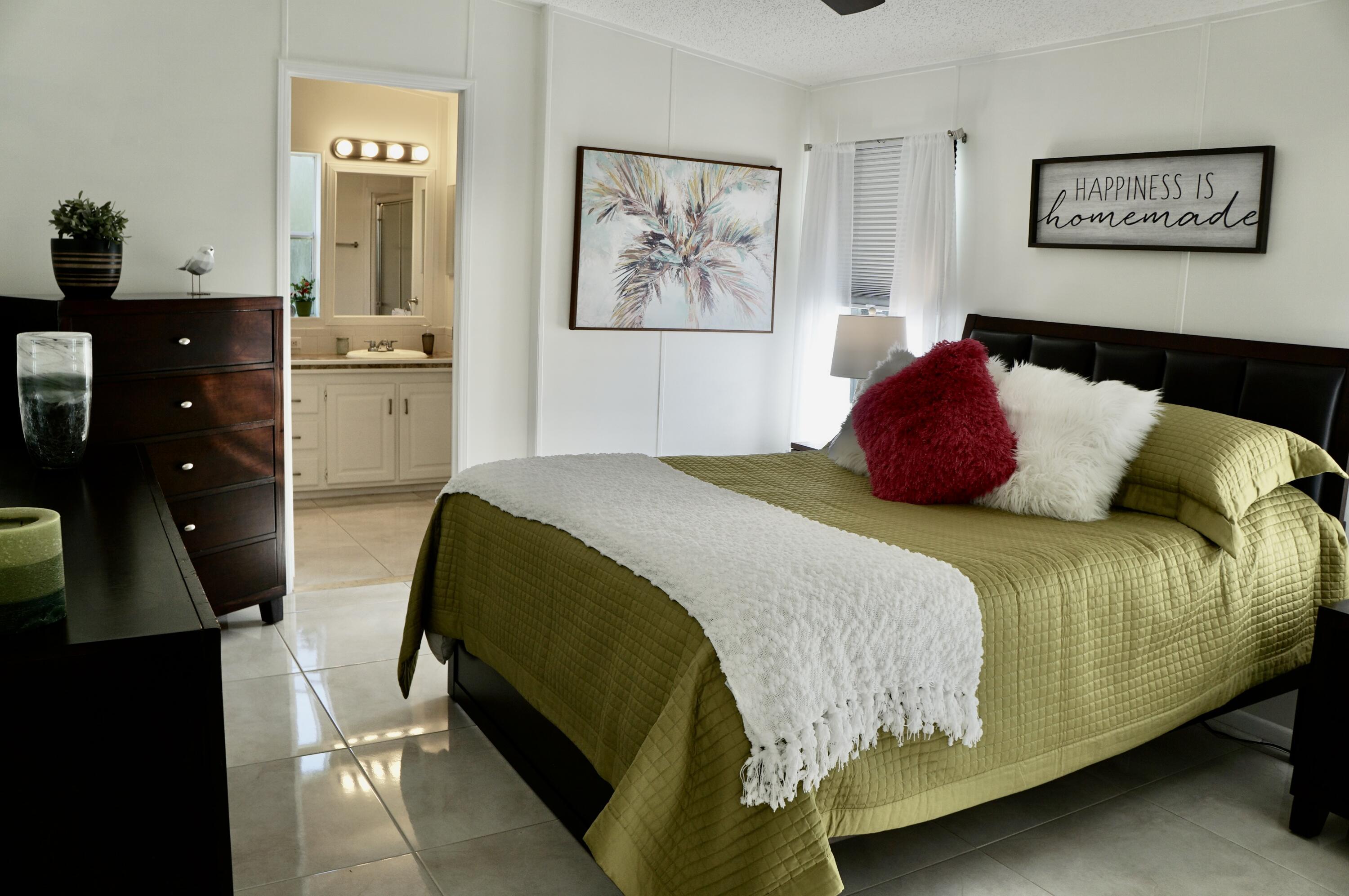 325 Mockingbird Avenue Fort Pierce, FL 34982 - Photo 14 of 39 a bedroom with a bed and wooden floor