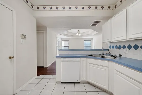 a kitchen with granite countertop white cabinets and white appliances