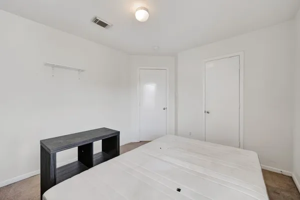 a bedroom with a bed and a lamp on the table