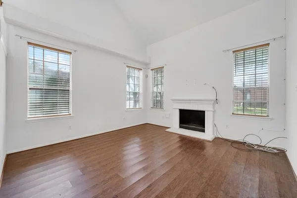 a view of an empty room with a window and fireplace
