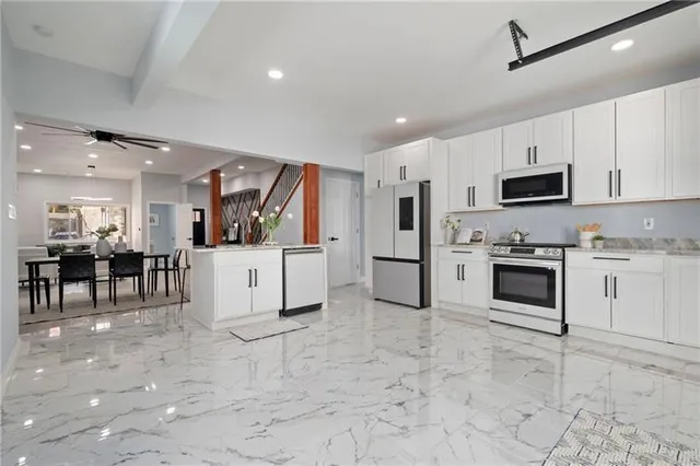 a kitchen with white cabinets and stainless steel appliances