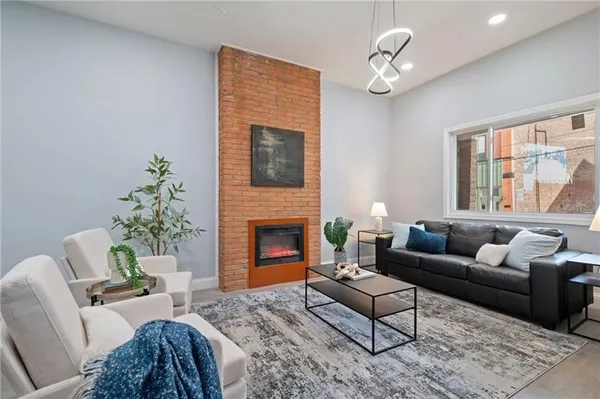 a living room with furniture a chandelier and a fireplace