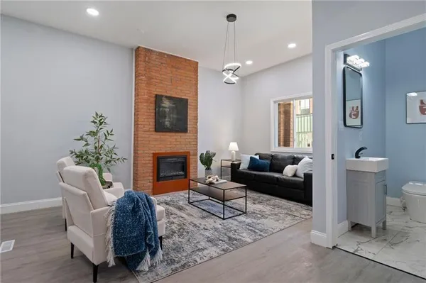 a living room with furniture a fireplace and a flat screen tv